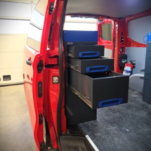 Ford Transit Custom L1 als Servicefahrzeug für einen Elektriker der Feuerwehr, ausgestattet mit einem 100 cm breiten und 96 cm hohen E-Flex Regalsystem auf der rechten Fahrzeugseite, bequem zugänglich durch die Schiebetür.