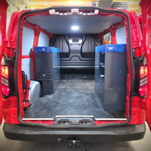 Ford Transit Custom L1 servicebil för räddningstjänstens elektriker, utrustad med E-Flex 100 cm förvaringssystem med hyllor, 96 cm högt, monterat på höger sida med enkel åtkomst genom skjutdörren.