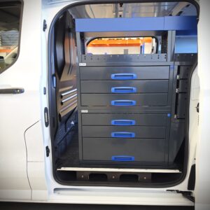 Ford Transit Custom avec rayonnage utilitaire de 230 cm et tiroirs supplémentaires, vue depuis la porte coulissante côté conducteur